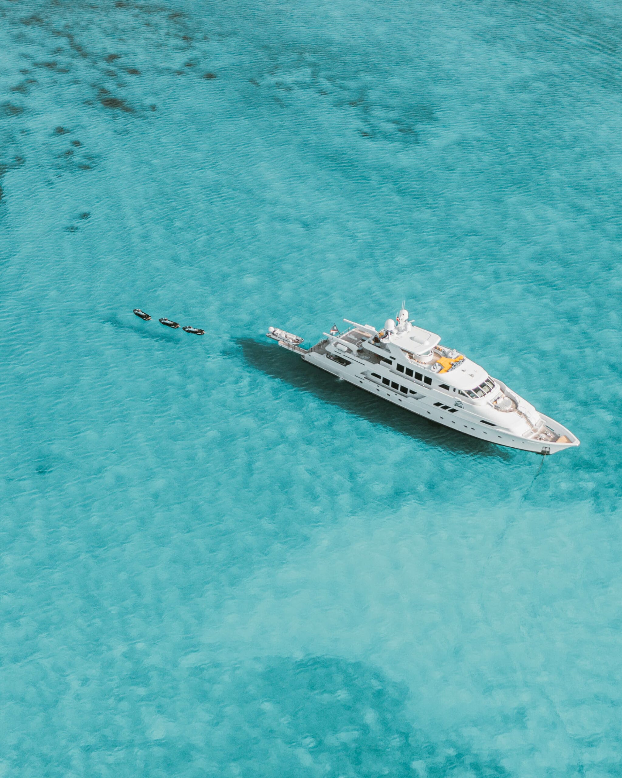 Superyacht at anchor in shallow turquoise water, Bahamas